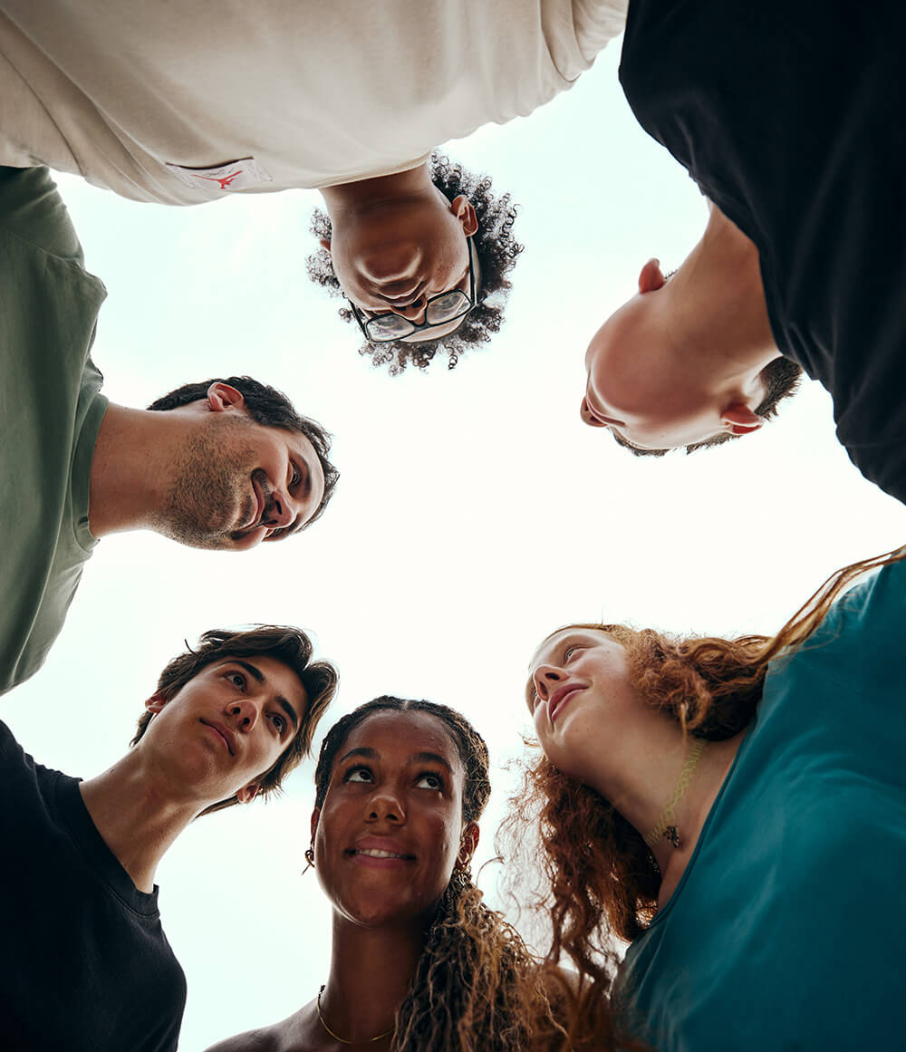 Foto von unten: Bundesminister Christoph Wiederkehr steht mit Schülerinnen und Schüler im Kreis
